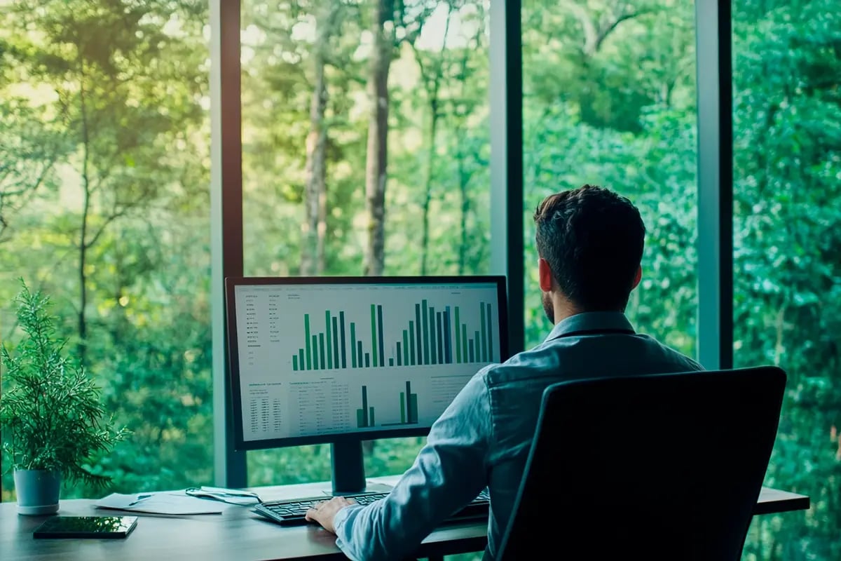 Breaking Down Carbon Pricing, What is Driving the Cost_A businessman focused on financial charts in his modern office and lush forest views_visual 1