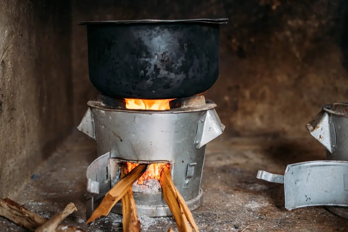 The Rise of Nature-Based Solutions in Carbon Offsetting_Close-up of an energy-efficient cookstove with a meal cooking on top_visual 3